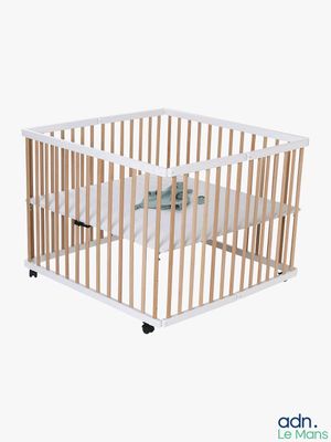 a small wooden crib with a mattress in it
