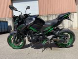 a picture of a black and green motorcycle parked in front of a building