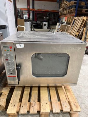 a silver microwave sitting on a pallet in a warehouse
