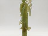statue d'une femme tenant une fleur à la main