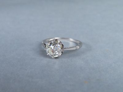 a close up of a diamond ring on a blue surface