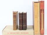 plusieurs vieux livres sont empilés sur une surface blanche