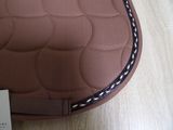 a brown saddle pad on a wooden table