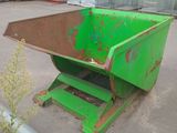 a green dumpster sitting in front of a building next to a fence