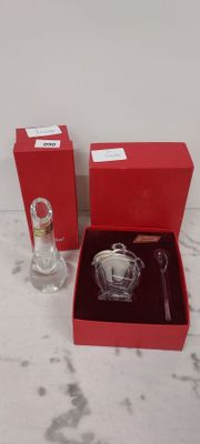 a red box with a glass bottle and a small glass bottle in it