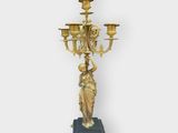 an antique brass candelab with a statue on top of it