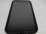 le dos d'un téléphone portable noir posé sur une table blanche