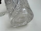 a glass jar with a lid sitting on a table next to a glass cup