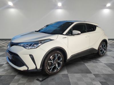 une Toyota C-HR blanche garée dans une pièce au sol à carreaux