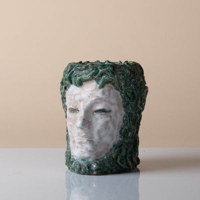 un gros plan sur une sculpture en céramique représentant le visage d'une femme