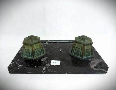 two small green houses sitting on a black base