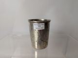 a silver cup sitting on a clear table
