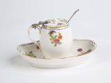 une tasse à thé et une soucoupe, avec une cuillère posée sur la soucoupe