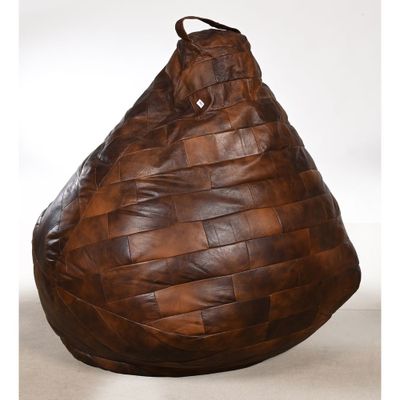 un pouf en cuir marron posé sur un sol blanc