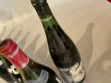 two empty wine bottles sitting on a table next to each other
