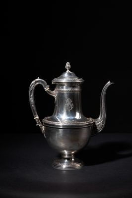 an antique silver teapot on a black background