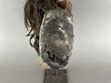 une sculpture représentant une tête de chien sur laquelle se trouve un poil