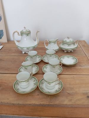 a wooden table with a tea pot and cups on it