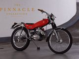 a red motorcycle parked in front of the pinnacle collection sign