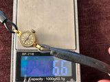 une personne tenant une montre sur une balance avec une paire de ciseaux
