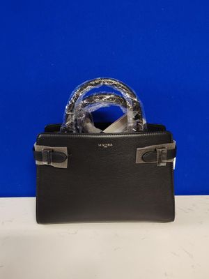 a black purse with a silver handle on a white table