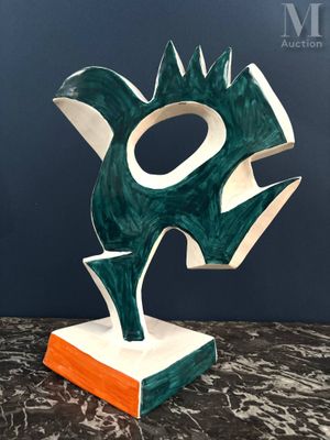 une sculpture verte et blanche posée sur une table en marbre
