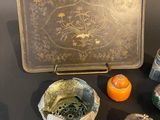 a metal tray with a design on it next to other items