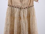 an old dress hanging on a hanger on a white wall