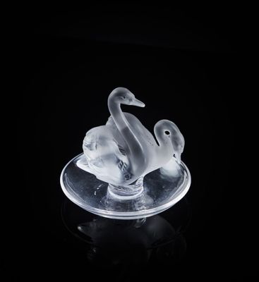 une sculpture en verre transparent représentant deux canards sur une assiette