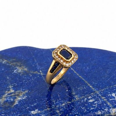 a close up of a gold ring on a blue stone