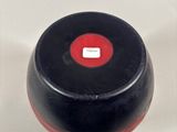a black and red object with a red button on it