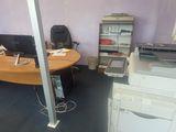 un bureau avec une imprimante posée dessus, dans une pièce