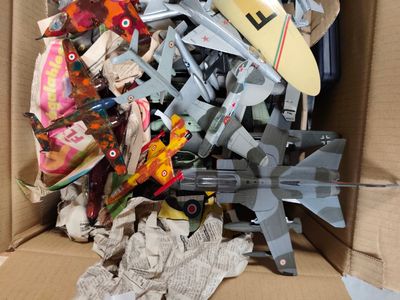 une boîte en carton remplie d'avions miniatures et d'autres jouets