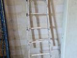 a ladder leaning against a wall next to a refrigerator