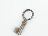 a small metal key that is on a white surface