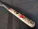 a knife with a floral design on it on a table