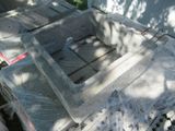 a concrete sink sitting in the middle of a pile of boxes