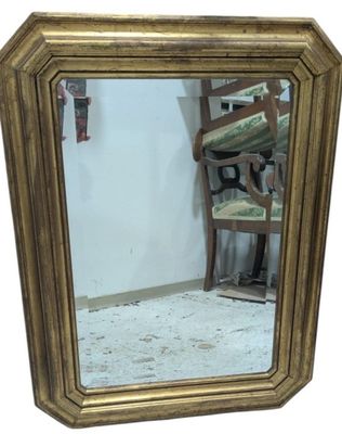 a mirror that is sitting on the floor next to a chair