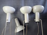 three white lamps on a wall with a black background