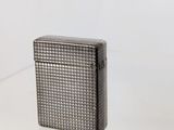 a silver lighter sitting on top of a white table