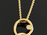 a close up of a gold necklace on a black surface