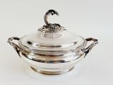 an antique silverplated bowl with a lid on a white surface