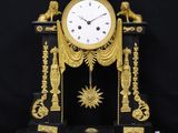 a black and gold clock sitting on a black table
