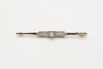 une broche antique en forme de barre sertie de diamants, sur fond blanc