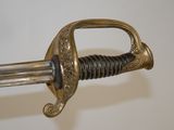 a close up of a sword on a white surface