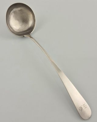 silver spoon with a long handle on a white surface