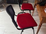 four red chairs sitting in front of a wooden table