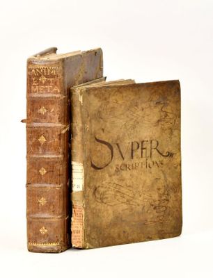 two old books sitting next to each other on a white surface