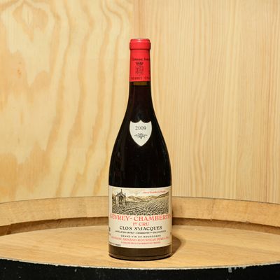a bottle of wine sitting on top of a barrel