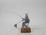 figurine of a man sitting on a chair with a fishing rod